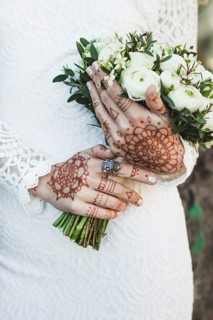 Nice wedding bouquet in bride's hand with mehendi tattoo